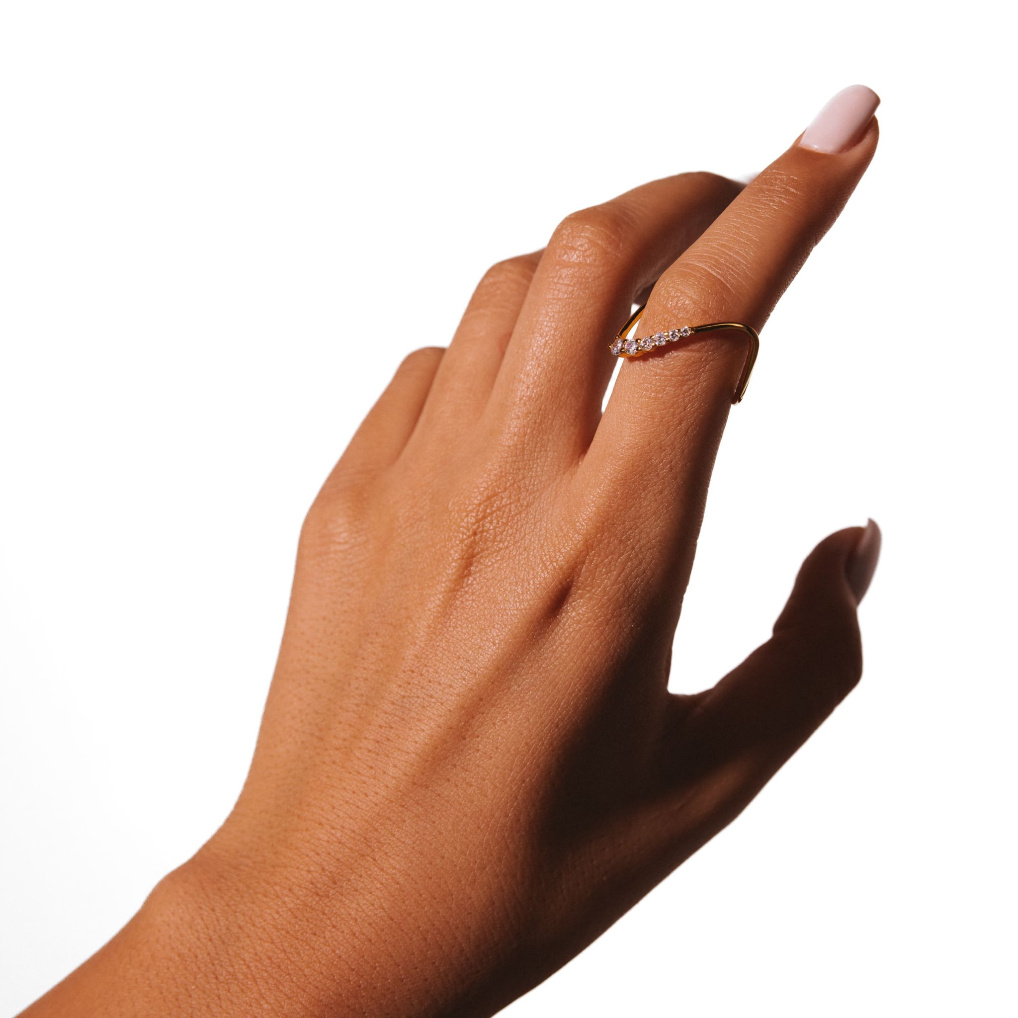 Alma ring worn on a raised hand against a white background.