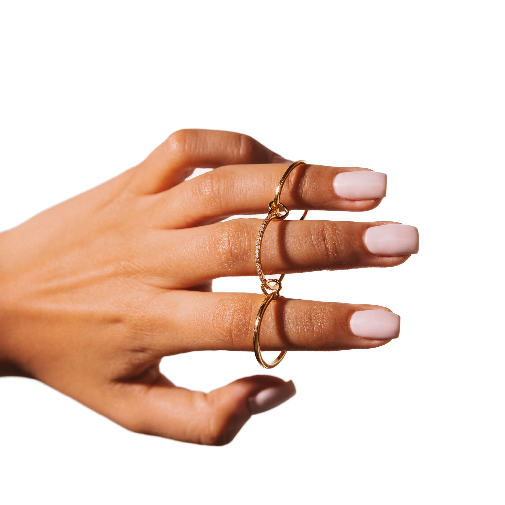 Juliet Rose ring worn on a hand, the linked bands resting across the fingers, against a white background.