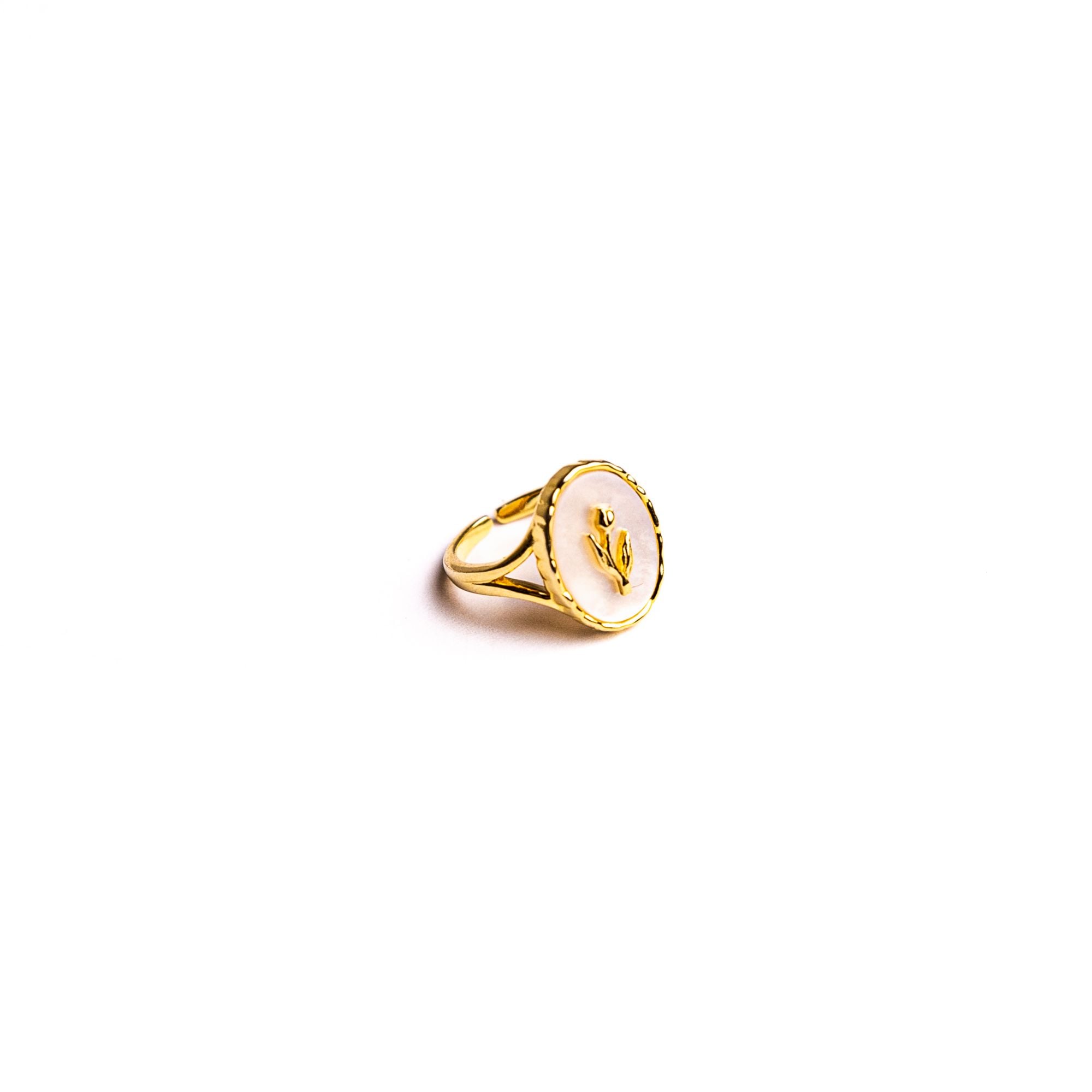 Zahra ring on a white background: an oval medallion with a small raised flower on a white face.